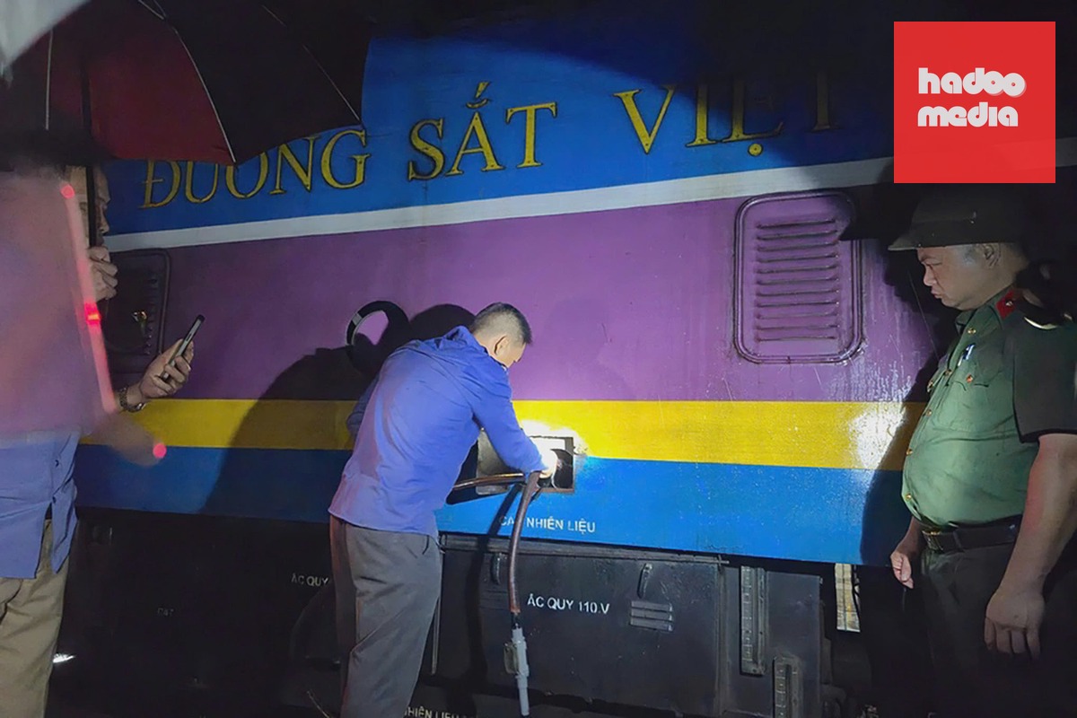 Cảnh sát bắt quả tang một nghi phạm đang hút trộm dầu tại đầu máy tàu hỏa ở Ga Vinh hồi cuối tháng 7. Ảnh: Hòa Vang