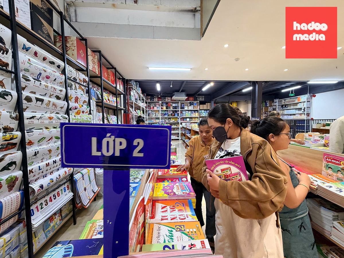 Chị Diệu (ôm sách) đi nhiều xã, phường vẫn chưa mua đủ sách cho con học lớp 2 - Ảnh: MINH PHƯƠNG