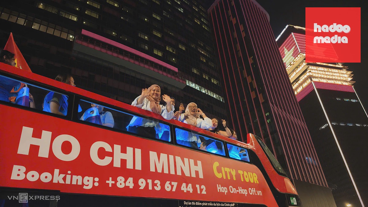 Nhiều du khách Hồi giáo đi trên xe buýt hai tầng qua cầu Ba Son cũng hò hét vui vẻ cùng đám đông bên dưới. Ảnh: Đình Văn