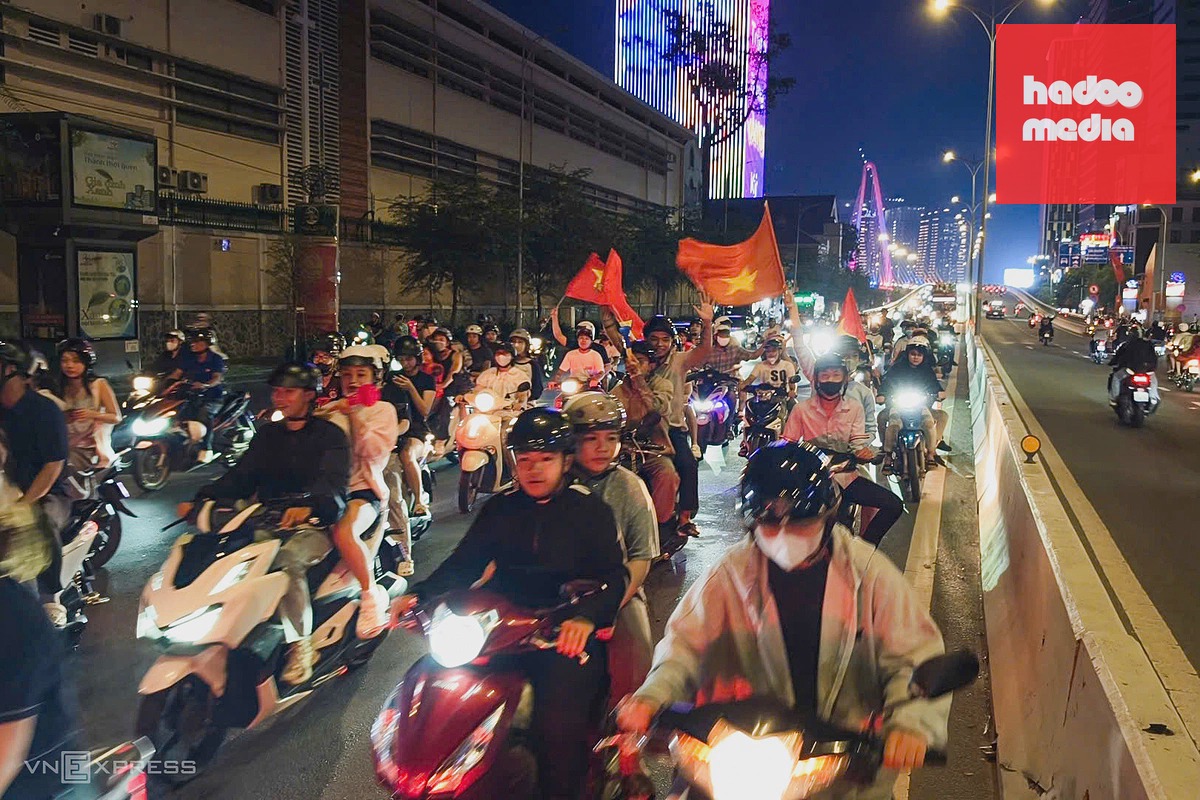 Người hâm mộ mang cờ Tổ quốc ăn mừng trên đường Tôn Đức Thắng - cầu Ba Son. Ảnh: Đình Văn