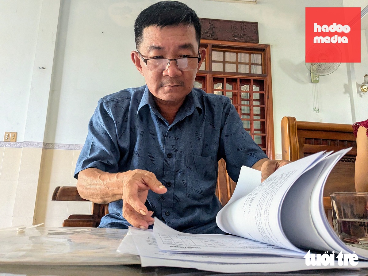 Ông Trung bên tập hồ sơ, đơn từ khiếu nại liên quan vụ việc - Ảnh: TẤN LỰC