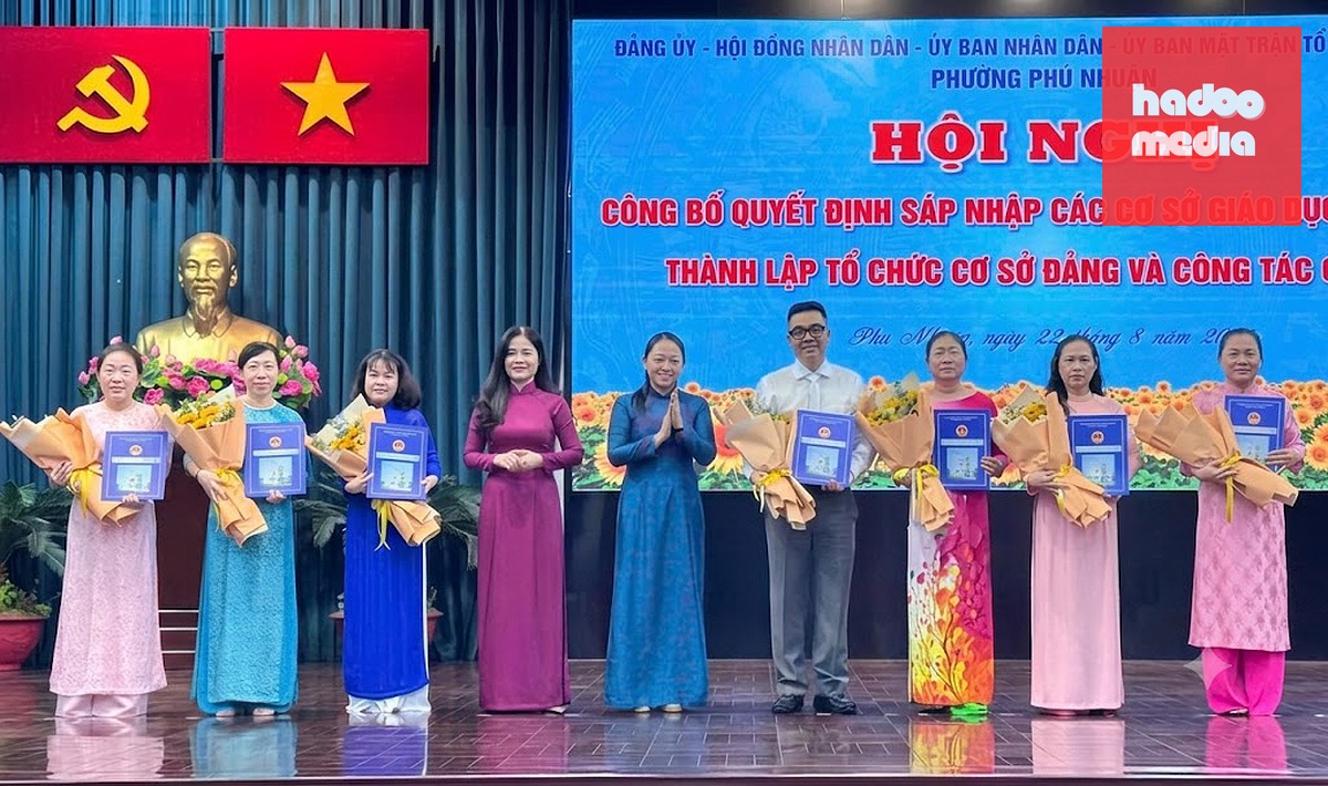Bà Lê Thị Bình, Phó chủ tịch UBND phường Phú Nhuận (thứ 4 từ trái qua) và bà Trần Huỳnh Nga - Trưởng Ban Xây dựng Đảng của phường (thứ 5 từ trái qua), trao quyết định thành lập trường và bổ nhiệm hiệu trưởng, hiệu phó cho 2 trường mầm non mới - Ảnh: L.B.