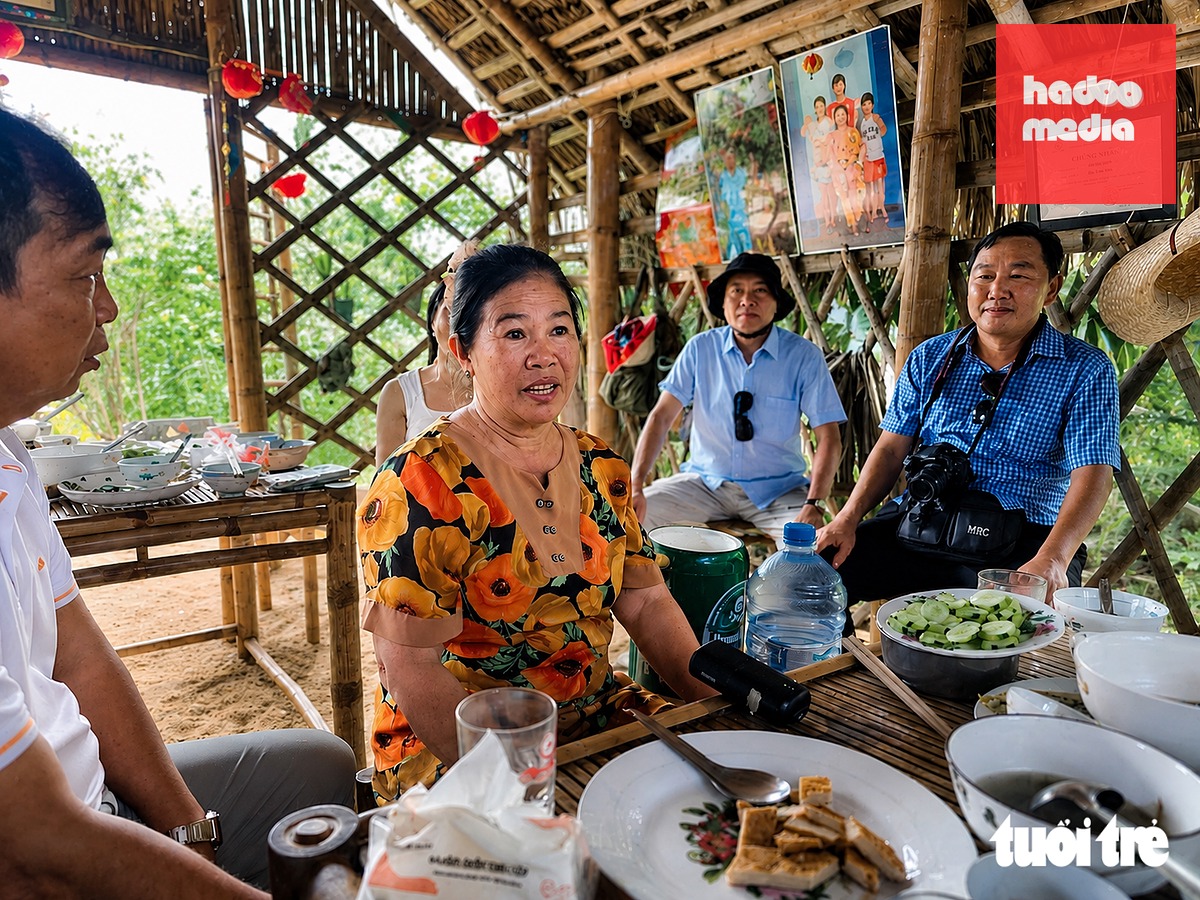 Bà Bùi Thị Sen (61 tuổi) hát bài chòi trong bữa cơm đãi khách, kể chuyện về làng Gò Cỏ - Ảnh: NHẬT XUÂN