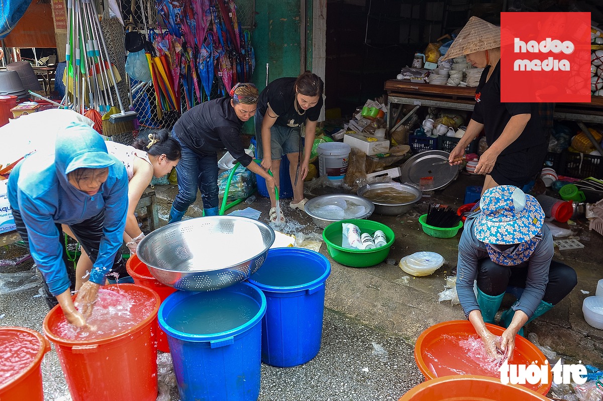 Nhiều cửa hàng trong chợ đang tất bật lau rửa hàng hóa để sớm mở cửa bán hàng trở lại - Ảnh: PHÚC TÀI