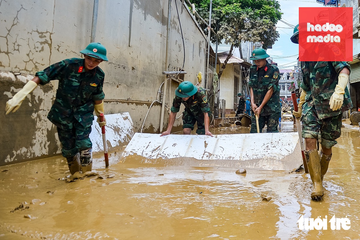 Những người lính khẩn trương dọn lớp bùn non để người dân sớm ổn định cuộc sống - Ảnh: PHÚC TÀI