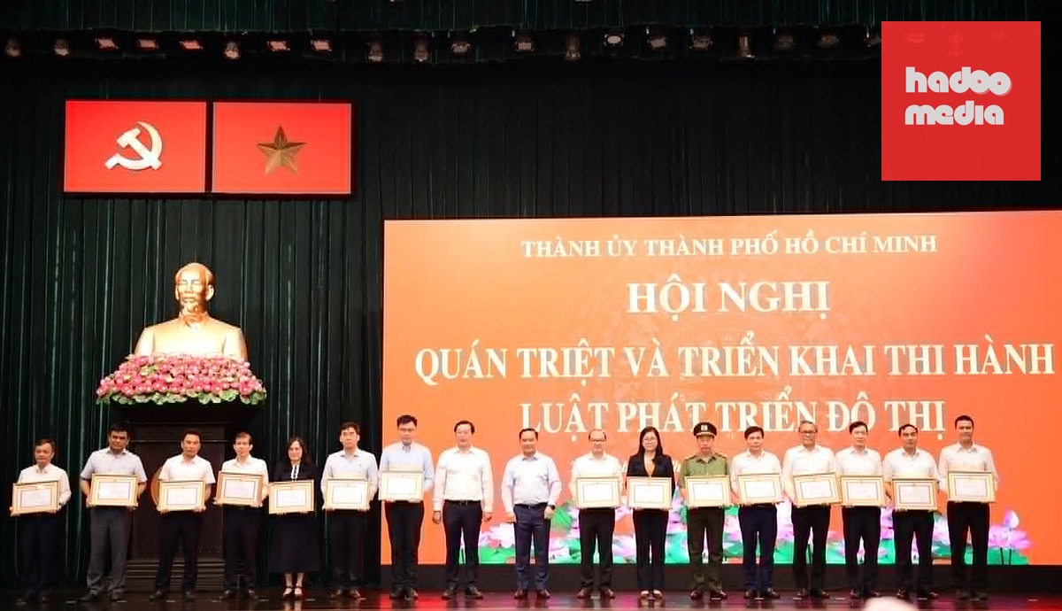 Phó bí thư thường trực Thành ủy TP.HCM Lê Quốc Phong và Phó bí thư Thành ủy, Chủ tịch UBND TP.HCM Nguyễn Văn Được tặng bằng khen cho các tập thể có thành tích trong xây dựng Luật Phát triển đô thị - Ảnh: QUANG ĐỊNH
