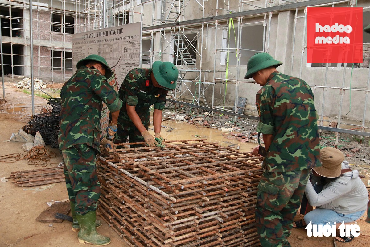 Các chiến sĩ bộ đội làm việc khẩn trương, quyết tâm xây dựng mái trường mới, mở thêm cơ hội học tập, sinh hoạt và phát triển cho trẻ em vùng khó khăn - Ảnh: DOÃN HÒA