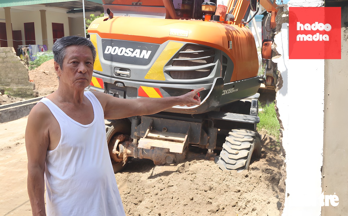 Ông Nguyễn Tùng Mậu - 79 tuổi, ngụ xã Kim Liên, Nghệ An - bên bức tường rào được tháo dỡ, hiến đất của gia đình để mở rộng đường - Ảnh: DOÃN HÒA