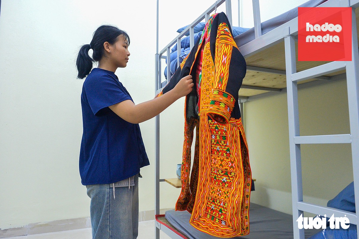 Em Triệu Tiểu Yến chỉnh trang lại bộ trang phục truyền thống để chuẩn bị cho lễ khai giảng - Ảnh: PHÚC TÀI
