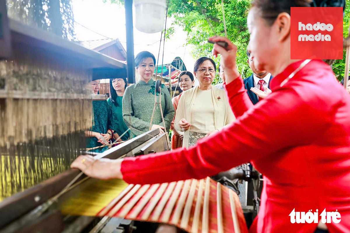 Hai Phu nhân xem nghệ nhân làng Vạn Phúc sử dụng khung dệt cổ - Ảnh: NGUYỄN KHÁNH