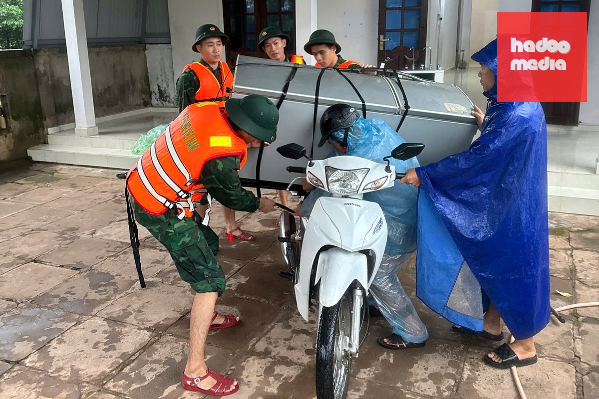 Các lực lượng hỗ trợ di dời tài sản người dân tránh mưa lũ - Ảnh: QUANG HÀ