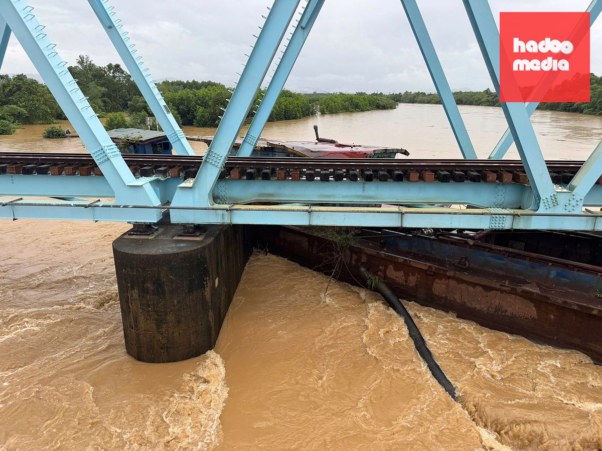 Một trong ba sà lan nạo hút cát mắc kẹt dưới cầu đường sắt Mỹ Chánh - Ảnh: QUANG HÀ
