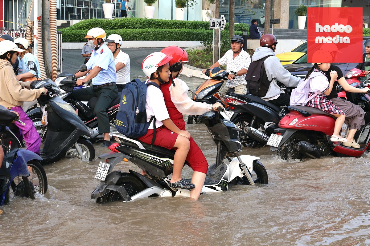 Thời điểm ngập là vào giờ đi học, đi làm nên gân khó khăn cho người dân - Ảnh: TRUNG PHẠM
