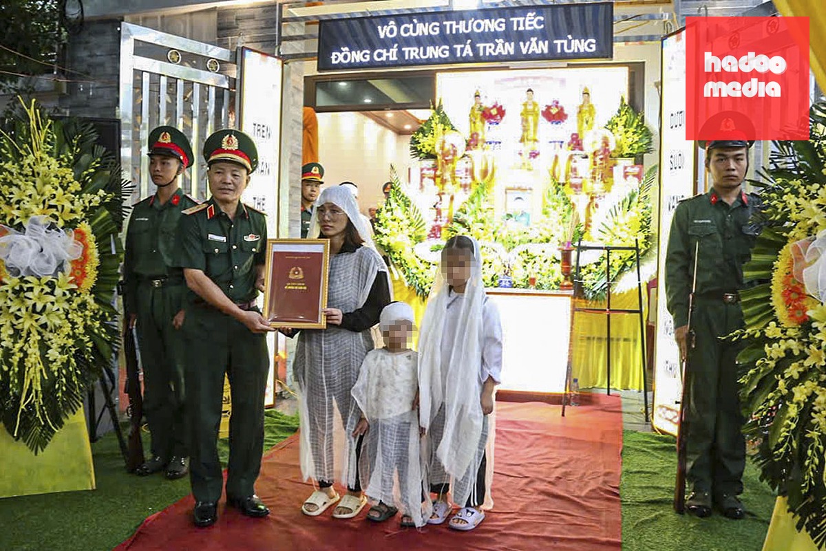 Trung tướng Lương Văn Kiểm - Tư lệnh Quân khu 3 - trao quyết định truy thăng quân hàm sĩ quan trước thời hạn cho thân nhân Trung tá Trần Văn Tùng - Ảnh: TRỊNH CƯỜNG