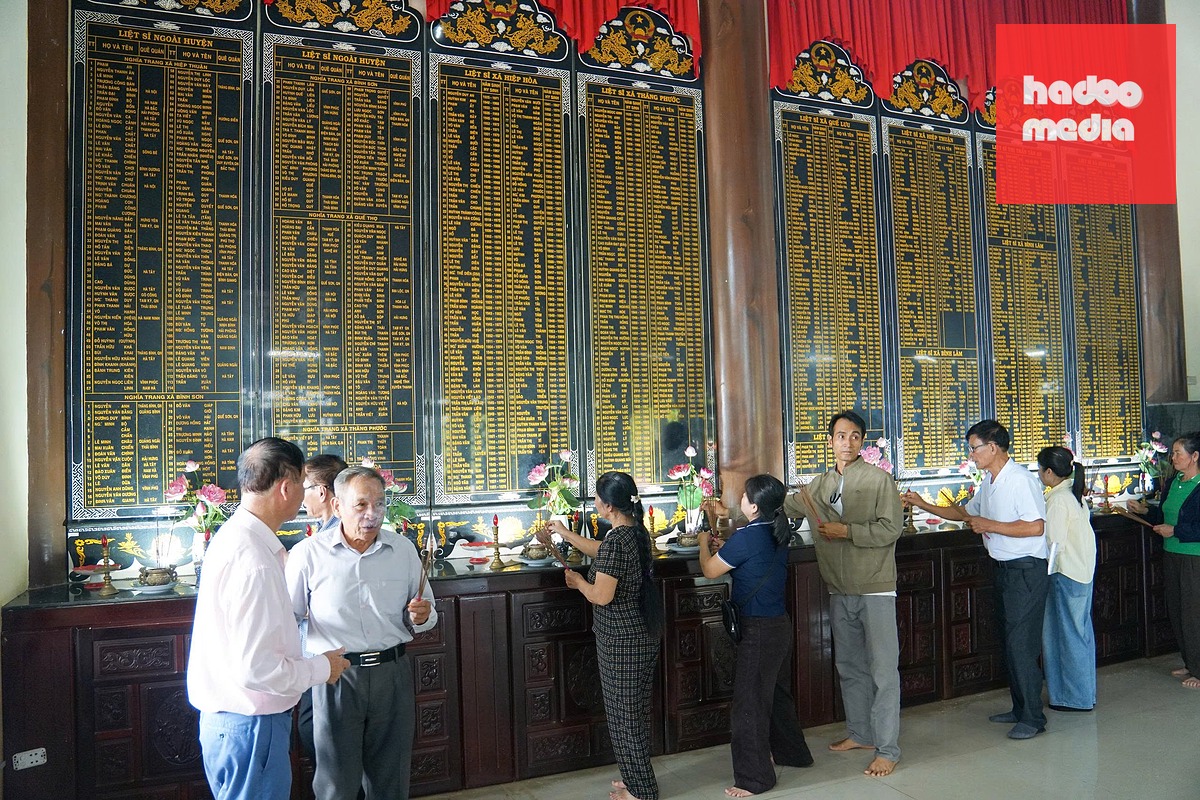 Các thân nhân liệt sĩ thắp hương trước chi chít hàng tên ghi danh liệt sĩ ở Nghĩa trang liệt sĩ Hiệp Đức - Ảnh: ĐẶNG NGỌC NGA
