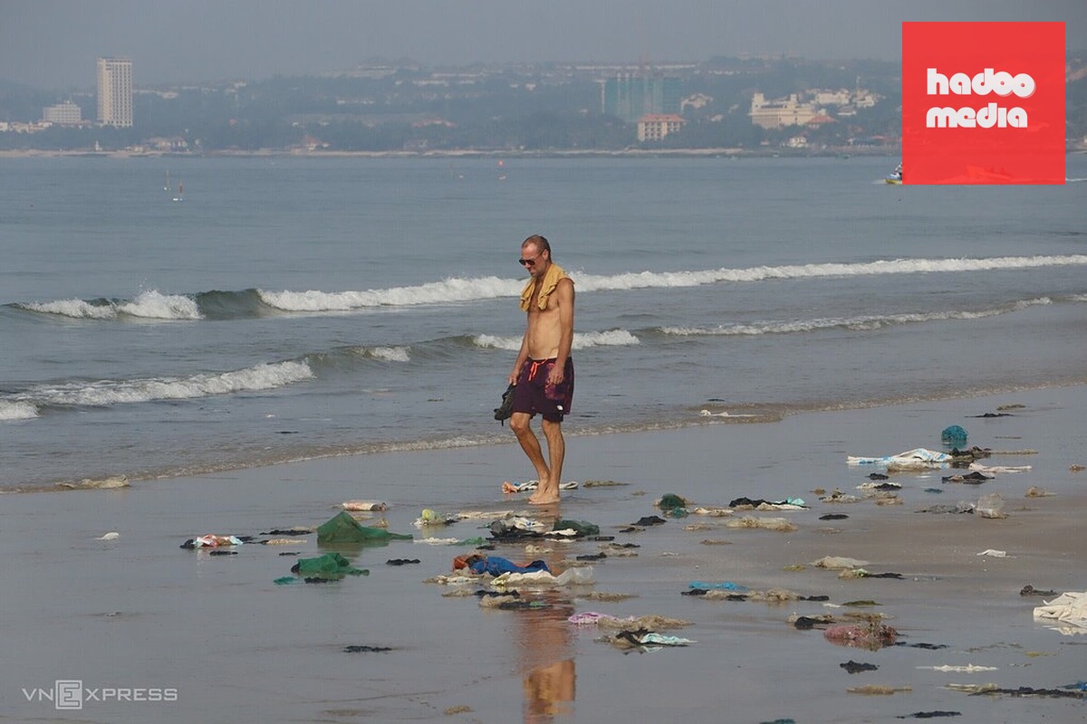 Du khách đi trên bãi biển đầy rác ở Mũi Né, ngày 16/9. Ảnh: Việt Quốc