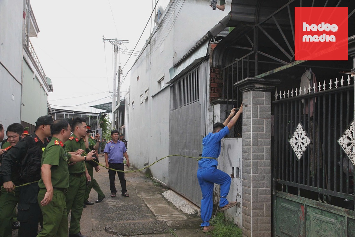 Nguyễn Đức Anh thực nghiệm quá trình leo rào lên mái nhà nạn nhân. Ảnh: Thái Hà