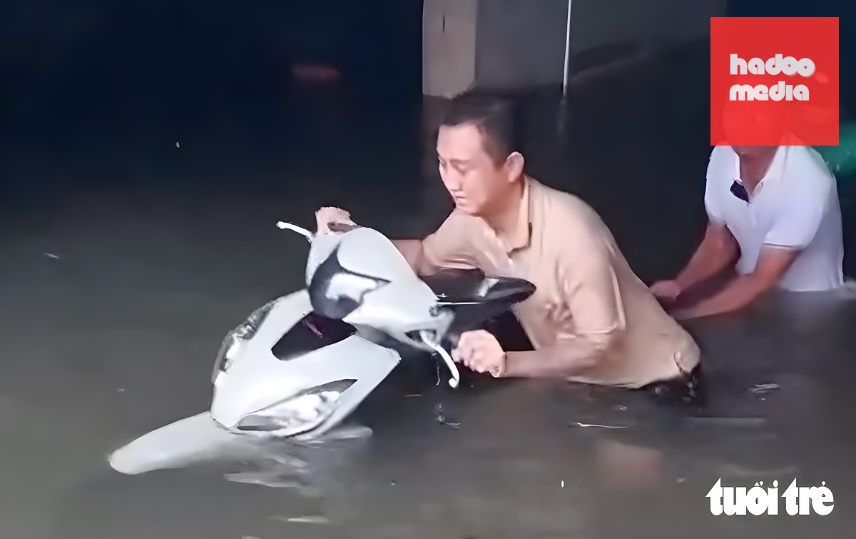 Người dân chung cư ở phường Hưng Bình (cũ), Nghệ An bì bõm lội nước cứu xe máy trong tầng hầm - Ảnh: Bạn đọc cung cấp