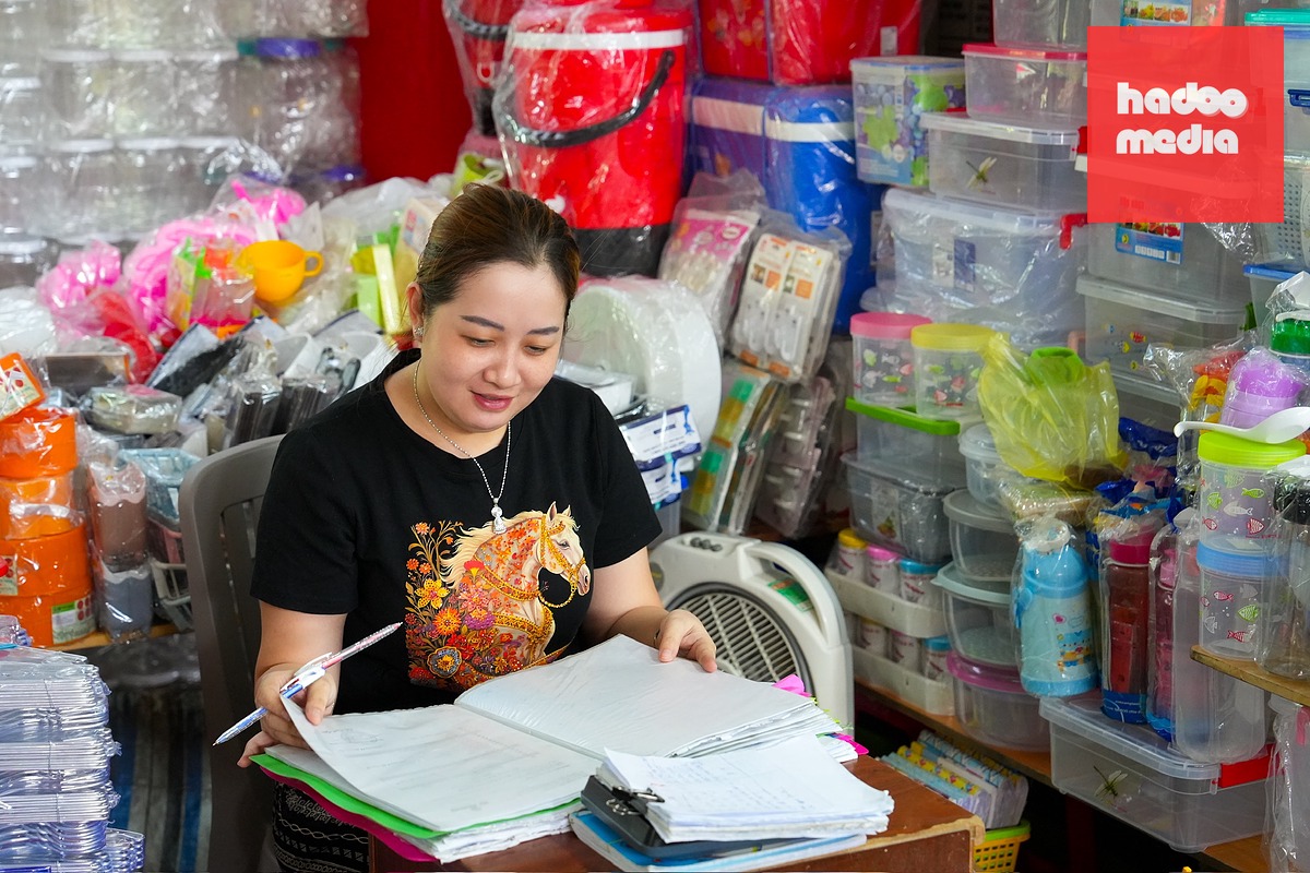 Tiểu thương quầy Diêm Thuận, chuyên mua bán các mặt hàng nhựa và melamine tại chợ Bình Tây (TP.HCM), kiểm tra sổ sách và tính toán hóa đơn - Ảnh: HỮU HẠNH