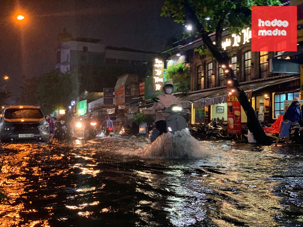 Đến hơn 7g30 tối, khu vực đường D5 (phường Thạnh Mỹ Tây) nước vẫn cao hơn bánh xe máy - Ảnh: NGỌC LÂN
