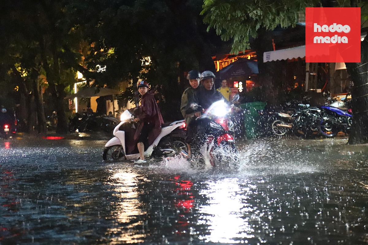 Đường ngập nước, nhiều xe máy suýt trượt ngã tại đường Xuân Thủy (phường An Khánh) - Ảnh: NGỌC LÂN