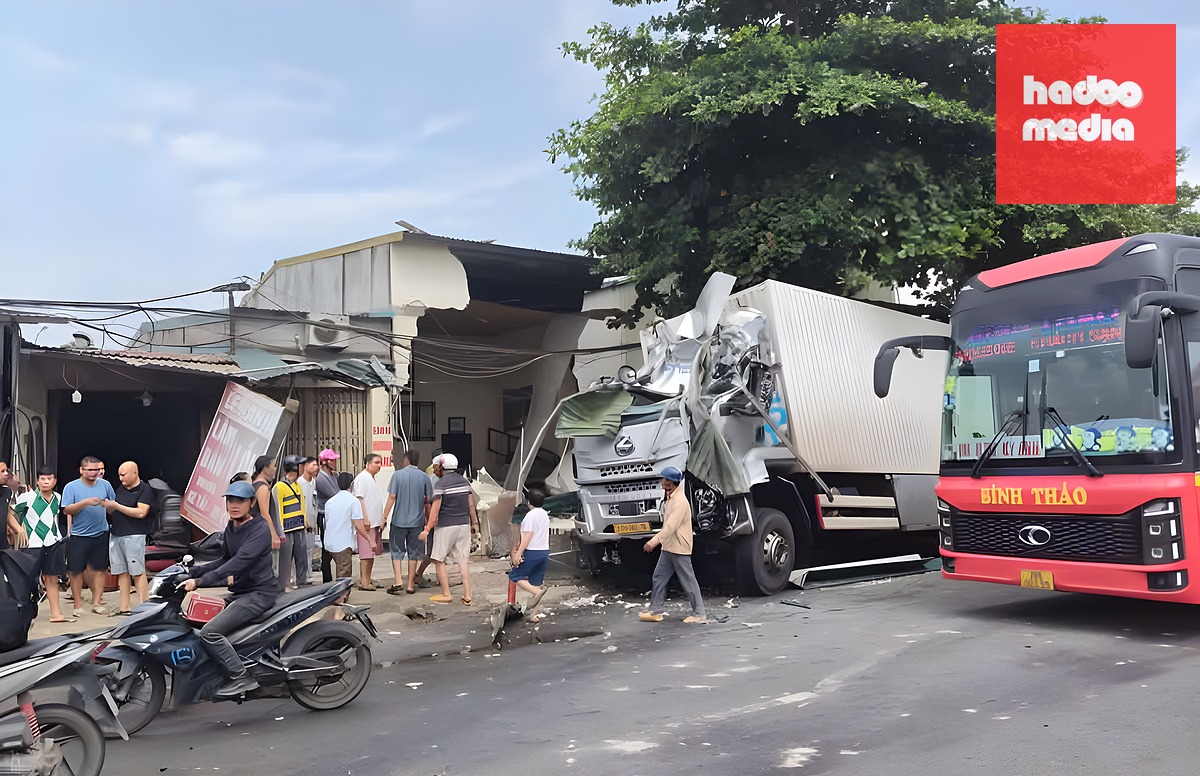 Xe tải vỡ nát cabin, bên cạnh là ngôi nhà bị sập. Ảnh: Nam Anh