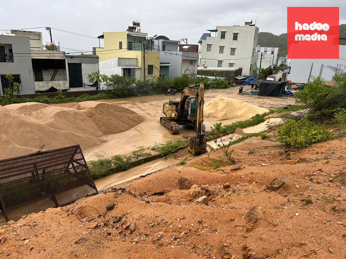 Xe múc được nhà thầu điều tới hiện trường nạo vét mương thoát nước để tránh ngập vào nhà dân - Ảnh: N.H.
