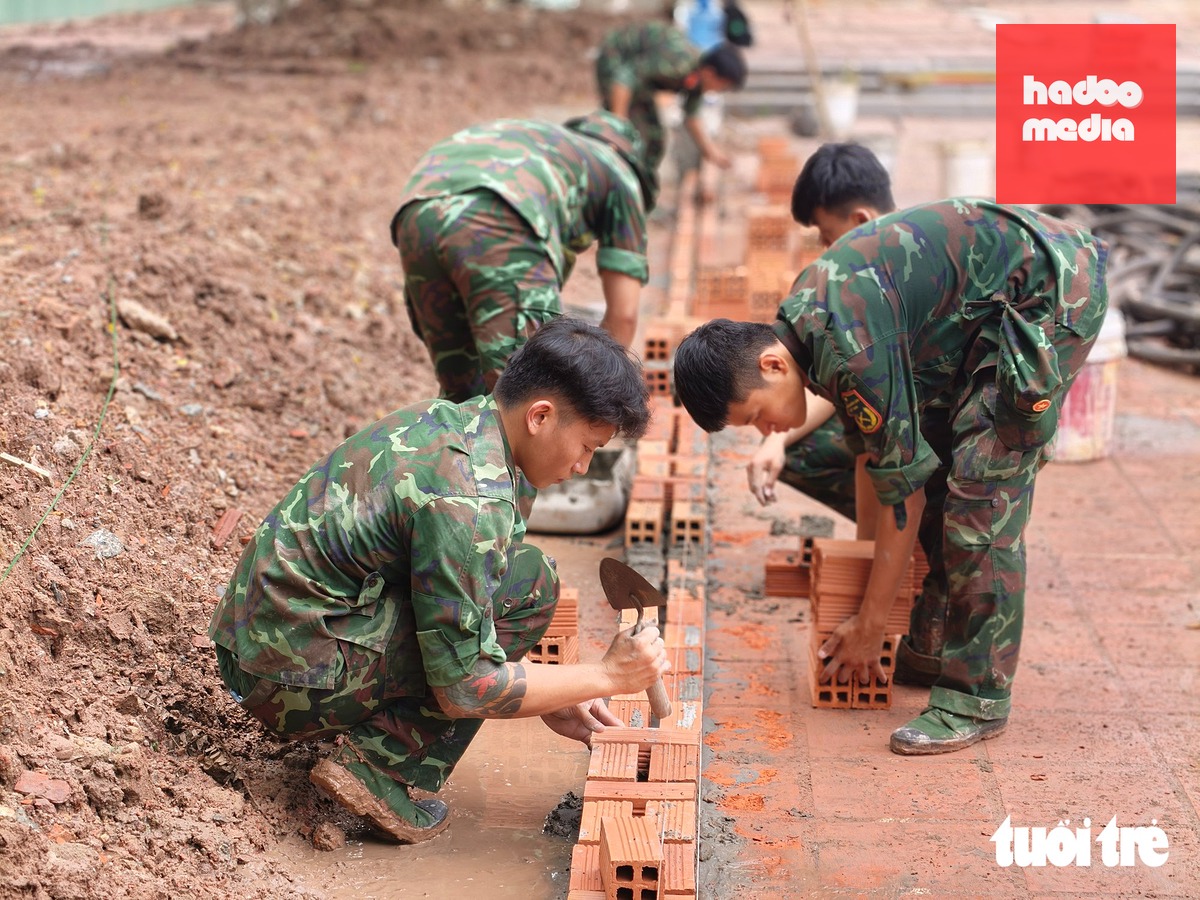 Sáng 24-9, các chiến sĩ xây dựng các hạng mục phục vụ cho lễ truy điệu, an táng hài cốt liệt sĩ tìm thấy tại công viên Lê Thị Riêng - Ảnh: TRÍ ĐỨC