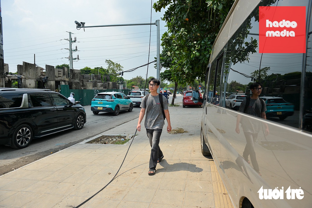 Hằng ngày, anh Đỗ Đức Duy phải đi bộ qua khu vực thi công đường nối Đỗ Đức Dục - Mễ Trì để đi học. Mùi rác thải bốc lên nồng nặc khiến Duy hết sức mệt mỏi - Ảnh: PHÚC TÀI