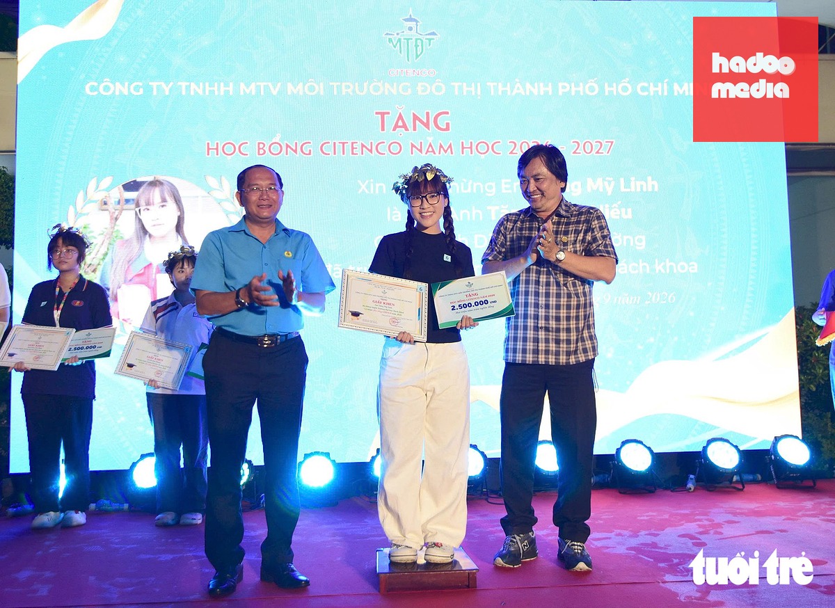 Ông Lê Công Phương, Giám đốc Công ty TNHH MTV Môi trường đô thị TP.HCM (phải) và đại diện Công đoàn TP.HCM trao học bổng - Ảnh: LÊ PHAN