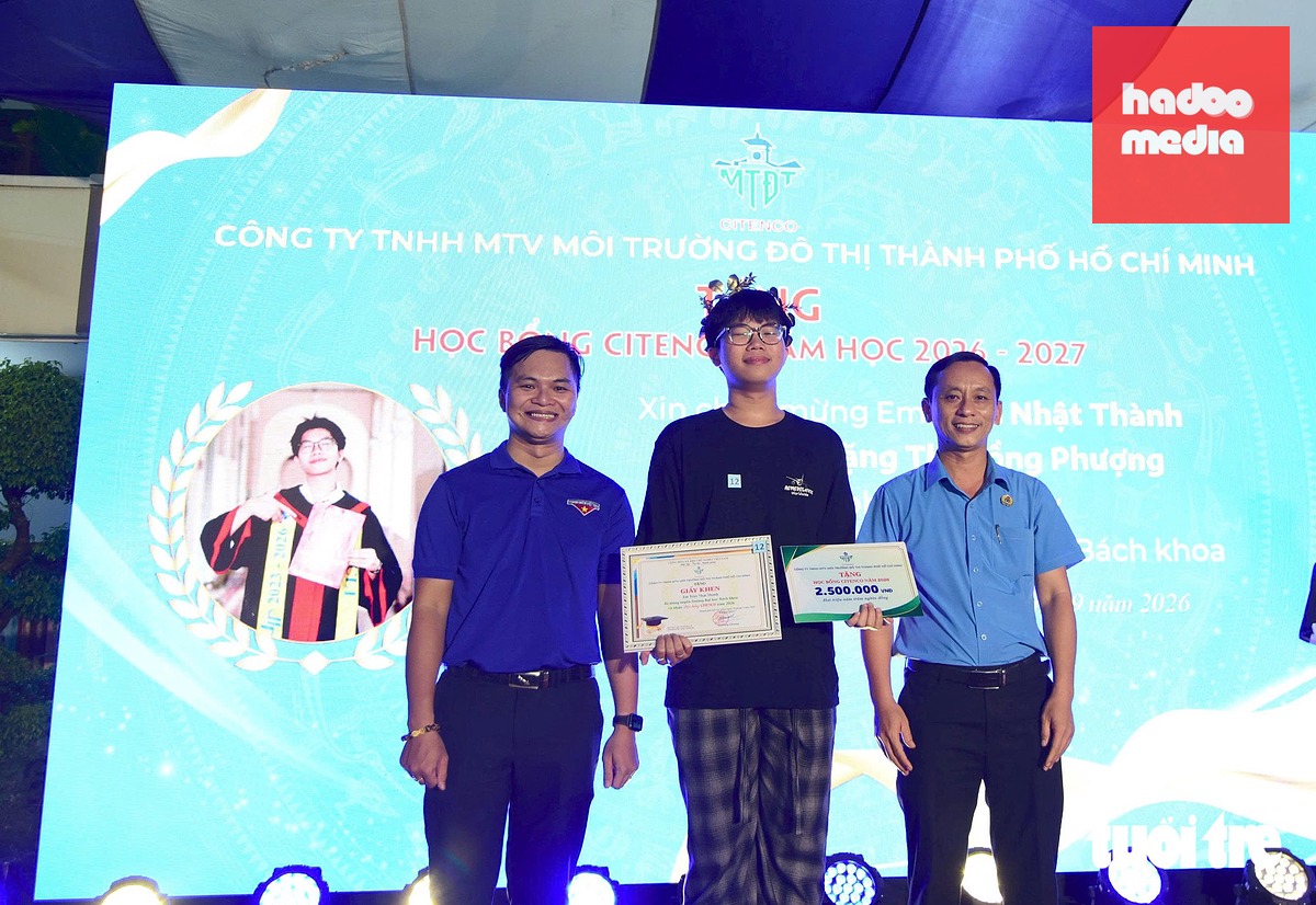 Ông Cao Văn Tuấn, thành viên chuyên trách HĐQT, Chủ tịch Công đoàn Công ty TNHH MTV Môi trường đô thị TP.HCM (bìa phải) và anh Trần Quốc Huy, Phó bí thư thường trực Đoàn thanh niên UBND TP.HCM trao học bổng - Ảnh: LÊ PHAN