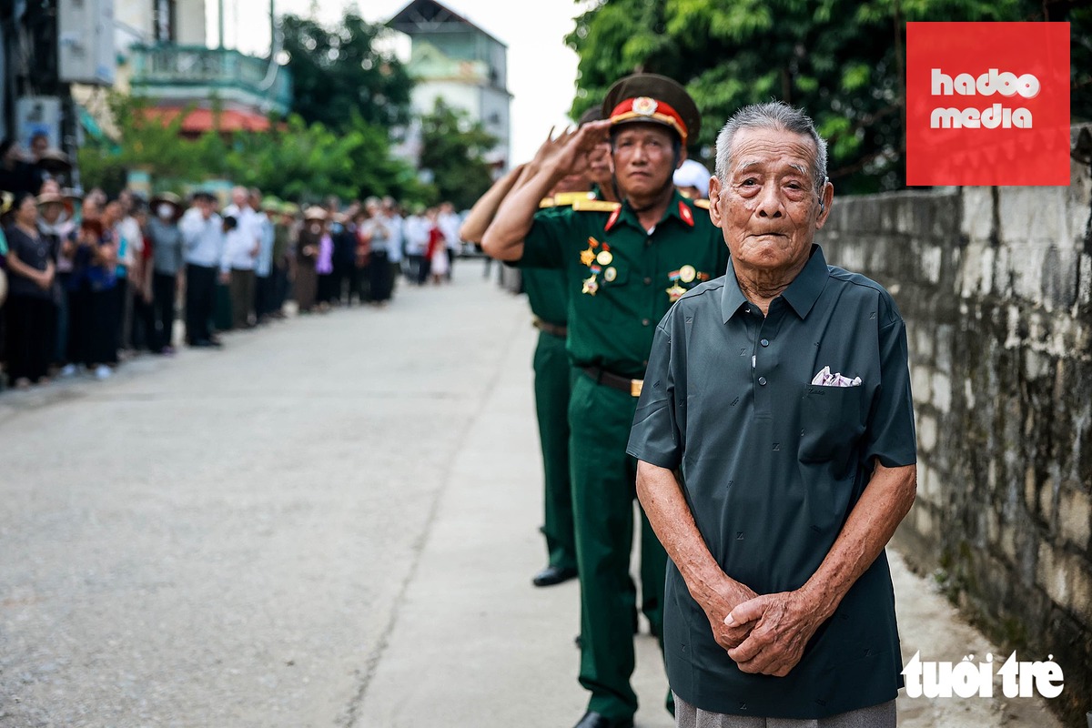 Cụ Phan Văn Cống (97 tuổi), cha của liệt sĩ Phan Văn Cánh, dõi mắt nhìn chiếc xe chở hài cốt của con trai chầm chậm trở về nhà - Ảnh: NGUYỄN KHÁNH