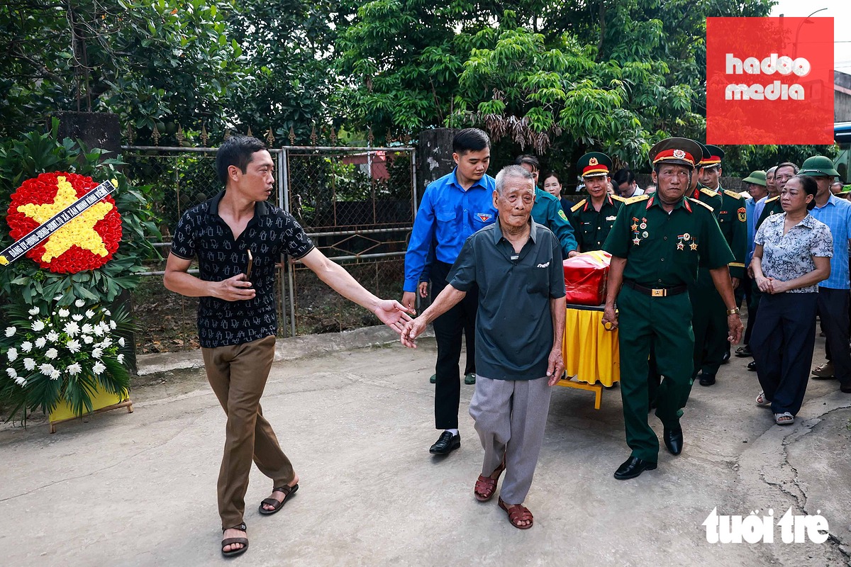 Cụ Phan Văn Cống (97 tuổi), cha của liệt sĩ Phan Văn Cánh, đi trước để đưa con trai về nhà sau 53 năm xa cách - Ảnh: NGUYỄN KHÁNH