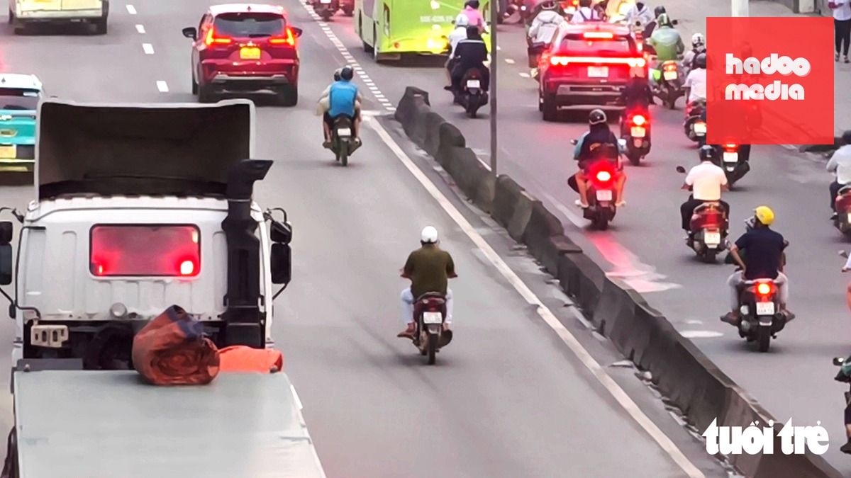 Hai xe máy chạy vào làn ô tô quốc lộ 22 (nay là đường Lê Quang Đạo, đoạn qua phường Trung Mỹ Tây) - Ảnh: NGỌC KHẢI