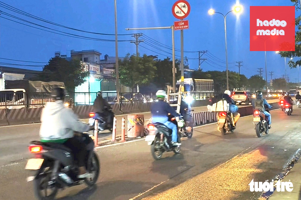 Một người lái xe máy chạy vào làn ô tô quốc lộ 1 (nay là đường Lê Đức Anh, đoạn qua xã Bà Điểm) - Ảnh: NGỌC KHẢI