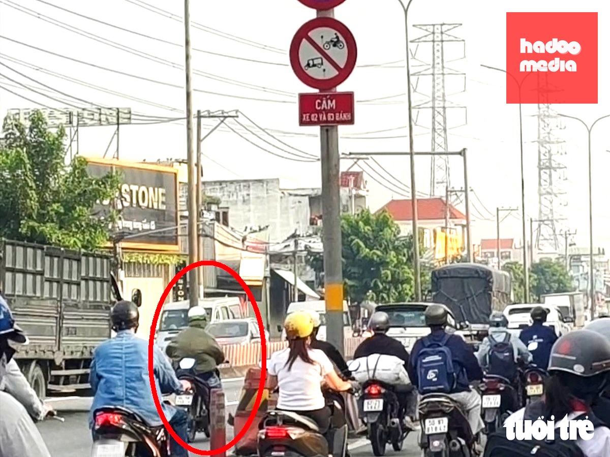 Một người chạy xe máy vào làn ô tô quốc lộ 1 (nay là đường Lê Đức Anh, đoạn qua phường Bình Hưng Hòa) - Ảnh: NGỌC KHẢI