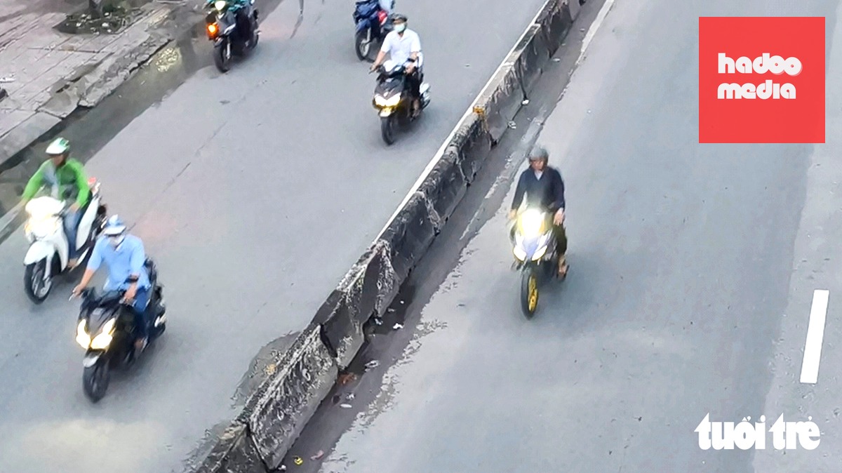 Một xe máy đi vào làn ô tô quốc lộ 22 (nay là đường Lê Quang Đạo, đoạn qua phường Trung Mỹ Tây) - Ảnh: NGỌC KHẢI