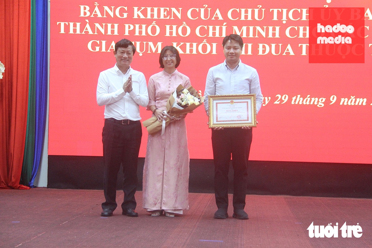 Phó bí thư Thành ủy, Chủ tịch HĐND TP.HCM Võ Văn Minh (bìa trái) trao bằng khen của UBND TP.HCM cho lãnh đạo UBND phường Thủ Dầu Một - Ảnh: BÁ SƠN