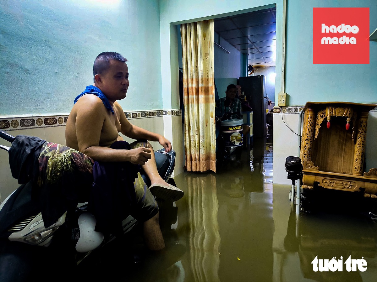 Nhiều hộ dân ở khu vực ngập sâu phải chủ động di dời người và tài sản ra khỏi khu vực bị nước bao vây. Một số người ở lại tối nay phải "ngồi ngủ" - Ảnh: CHÂU TUẤN