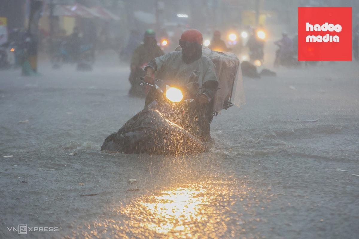Nước chảy cuồn cuộn trên đường Tô Ngọc Vân trong trận mưa lớn chiều 30/9, khiến người dân chật vật đi lại. Ảnh: Quỳnh Trần