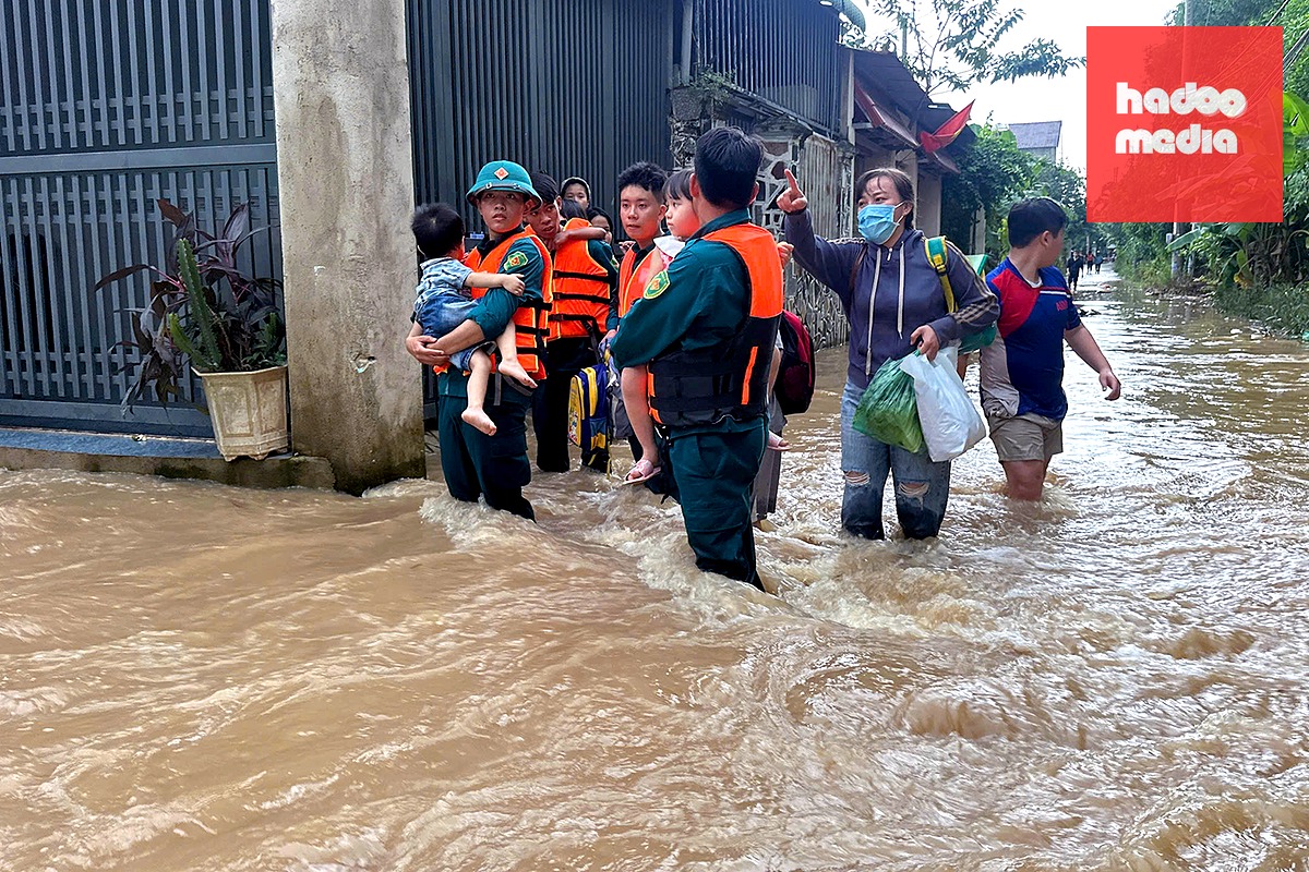 Đến sáng 1-10, tình trạng ngập ở khu phố Hương Phước, xã Phước Tân, TP Đồng Nai đã ổn. Trong ảnh: Lực lượng chức năng địa phương hỗ trợ người dân qua vùng ngập - Ảnh: A.B.