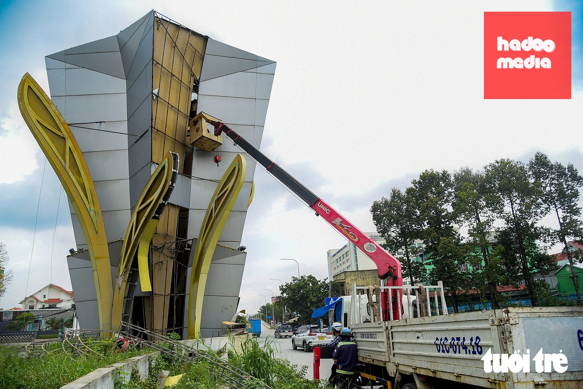 Các công nhân tiếp tục tháo dỡ các hạng mục còn lại của cổng chào Bình Dương cũ - Ảnh: TRÍ ĐỨC
