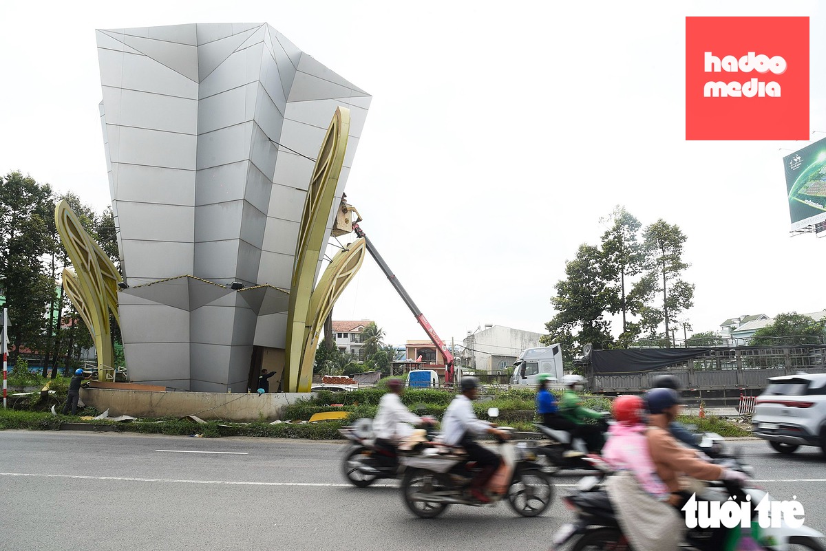 Nhiều người dân cho biết có chút tiếc nuối khi từ nay không còn nhìn thấy hình ảnh cổng chào quen thuộc suốt chục năm qua, tuy nhiên vì phục vụ dự án hạ tầng mở rộng quốc lộ 13 nên họ cũng thấy phấn khởi - Ảnh: TRÍ ĐỨC