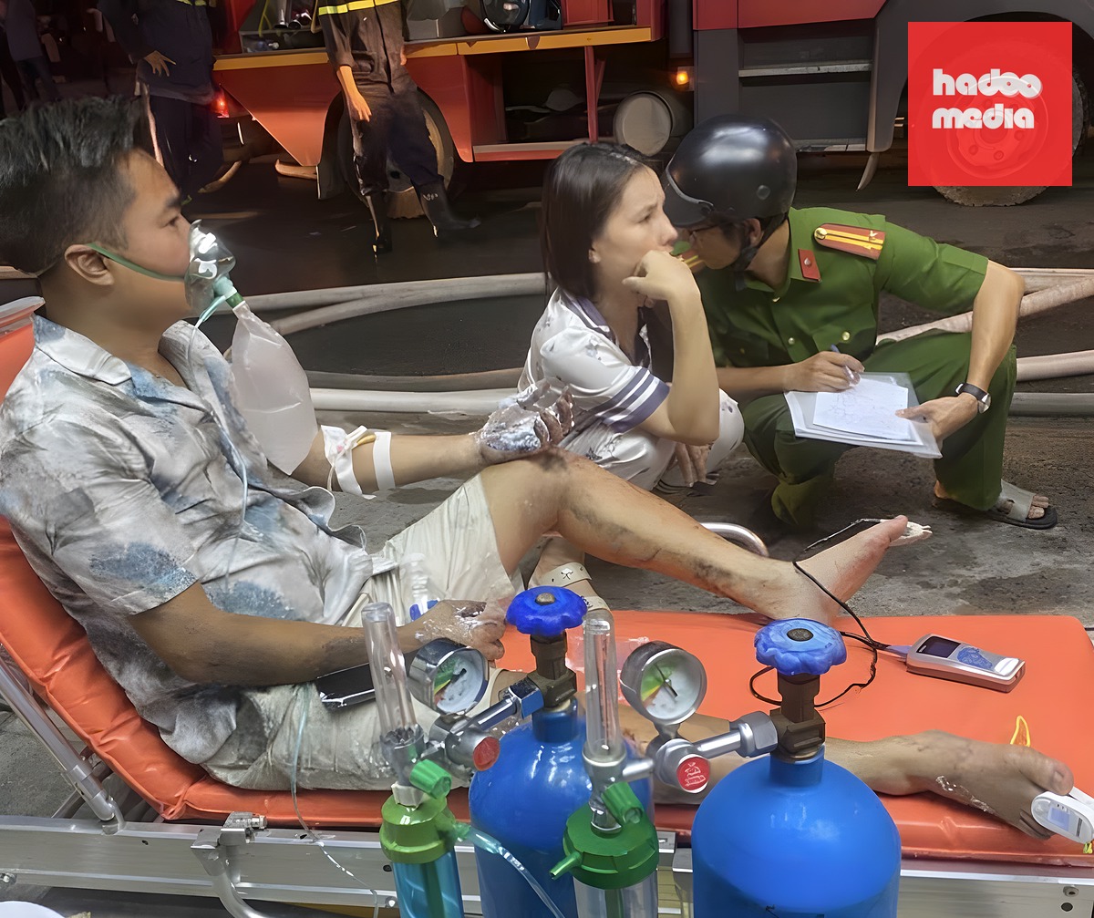 Người đàn ông bị bỏng chạy ra từ cửa hàng cháy, được cấp cứu, thở oxy tại hiện trường. Ảnh: Minh Bằng