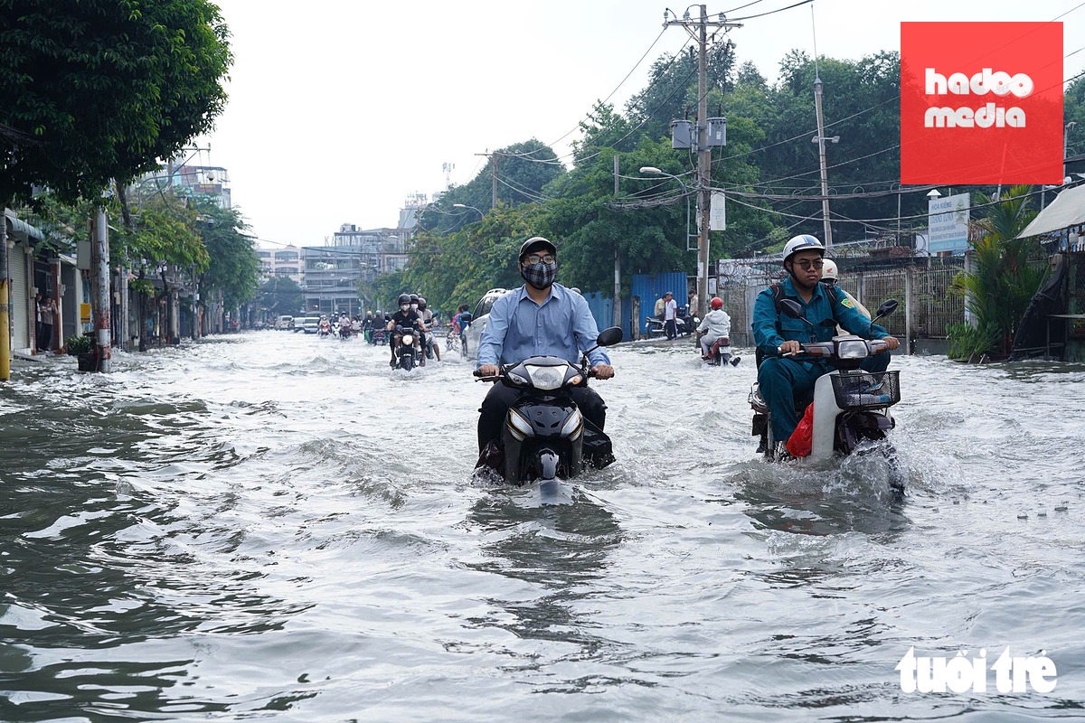 Trên đường Nguyễn Văn Khối nước ngập hơn nửa bánh xe, cả con đường mênh mông nước - Ảnh: CAM LY