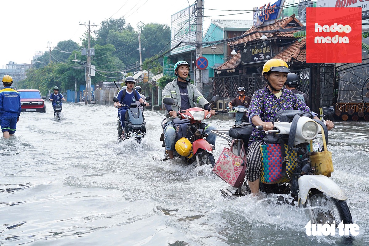 Đến 8h30 cùng ngày nước vẫn chưa rút, ngập nước khiến việc đi lại của người dân gặp nhiều khó khăn - Ảnh: CAM LY