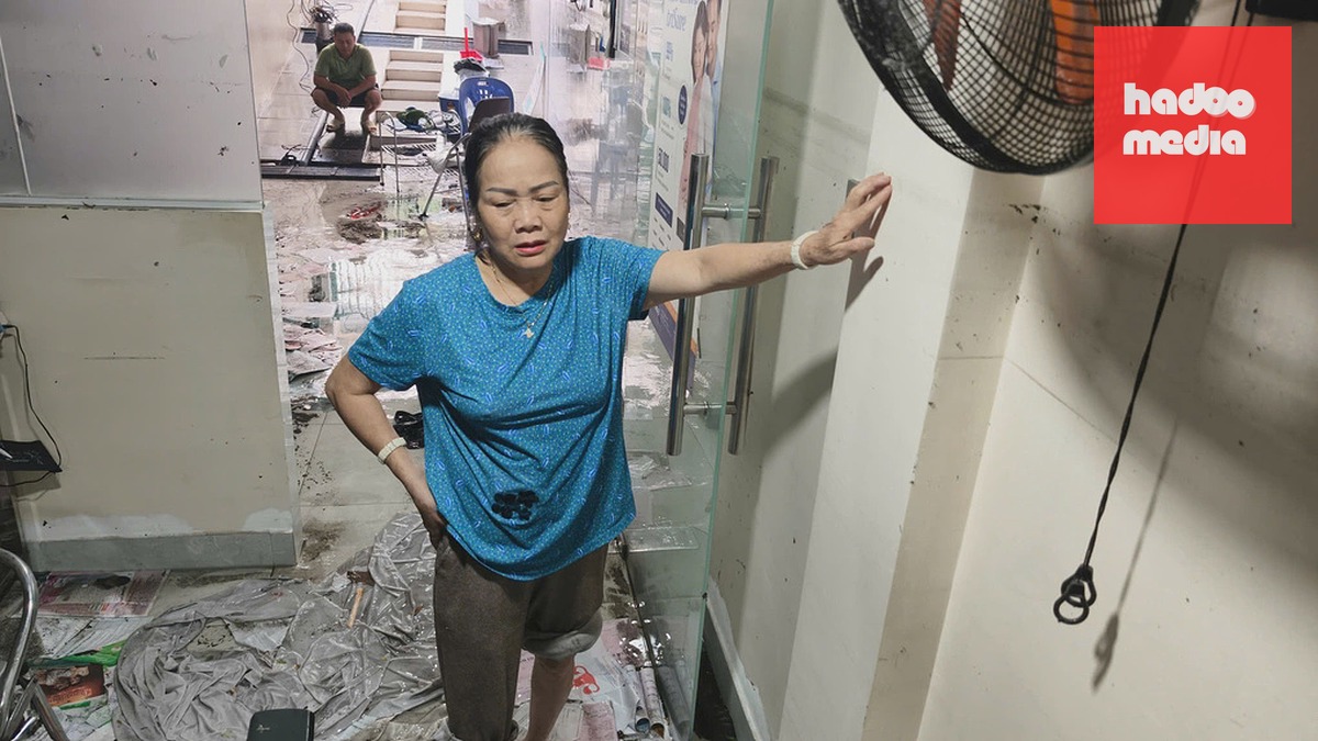 Bà Hường chỉ vào vệt nước cao ngang đầu sau khi nước rút trong căn biệt thự của gia đình. Ảnh: Đình Văn