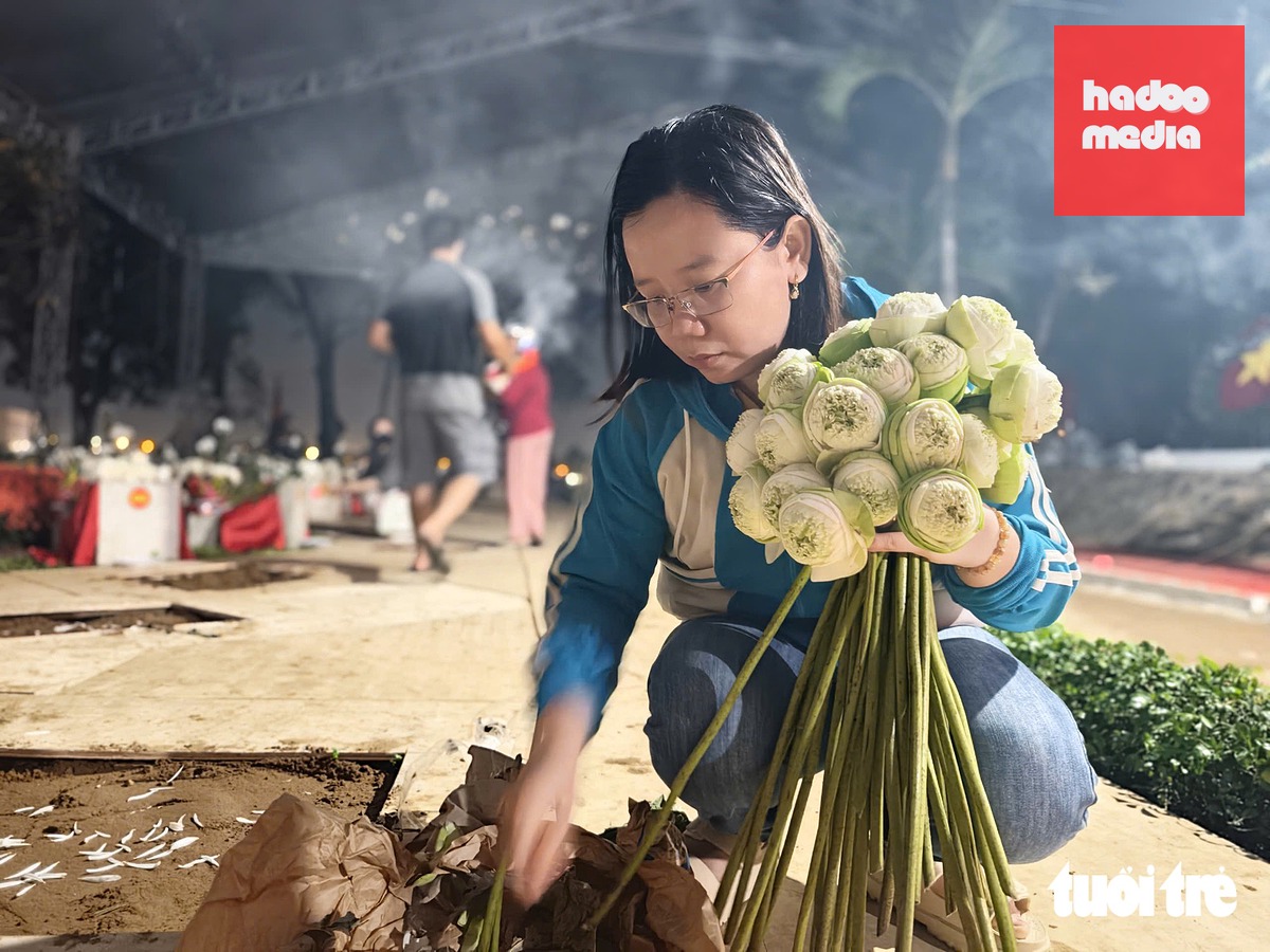 Chị Trang Thị Phương Kiều tranh thủ tan giờ làm đến dâng những bó hoa lên các anh hùng liệt sĩ - Ảnh: TRÍ ĐỨC