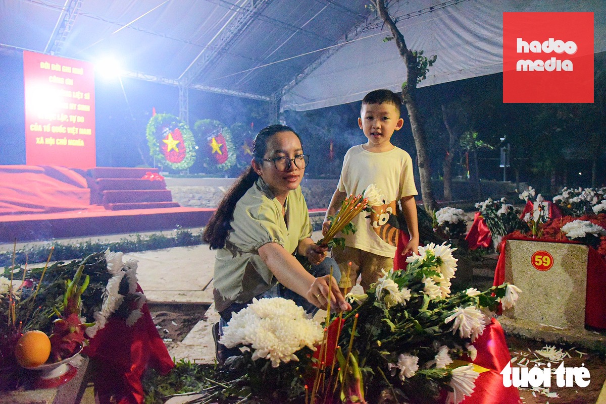 Em nhỏ theo mẹ đến dâng hương cho các anh hùng liệt sĩ vừa được an táng ở Nghĩa trang liệt sĩ TP.HCM tối 14-10 - Ảnh: TRÍ ĐỨC