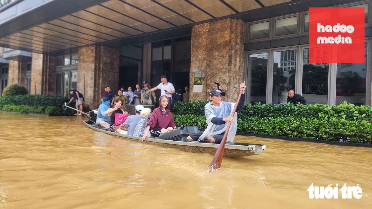 Du khách, người dân ở Huế mắc kẹt, phải dùng ghe đi lại giữa đường phố trong trận lũ vào tháng 10-2025 - Ảnh: NHẬT LINH